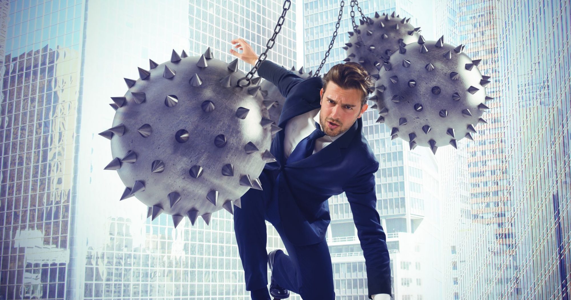 Businessman hindered by balls balanced on rope